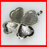 A sterling silver heart-shaped locket with clover shaped details on the sides, designed to hold four pictures.